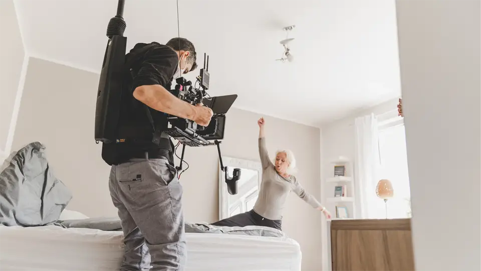 Eine Frau tanzt in dem Schlafzimmer auf eimen Filmset bei der Werbefilmproduktion für Zehnder